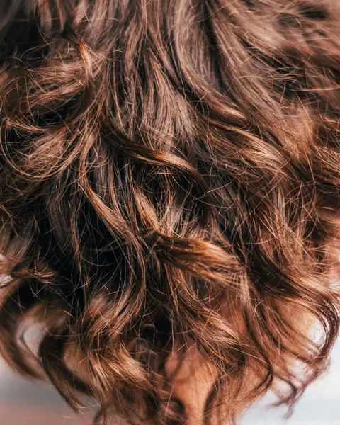 Beispielfoto: kastanienbraune Locken in Nahaufnahme