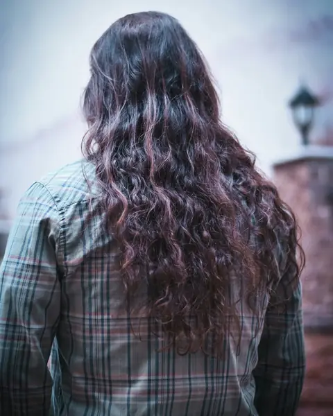 Beispielfoto: lange, wellige dunkelbraune Haare von hinten