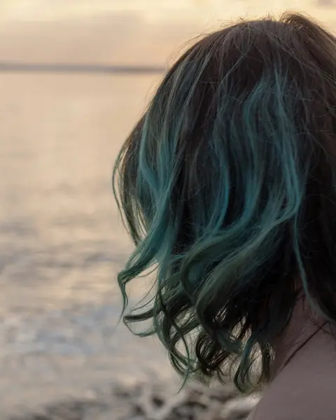 Beispielfoto: dunkle, gewellte Haare mit blaugrünen Strähnen, von hinten